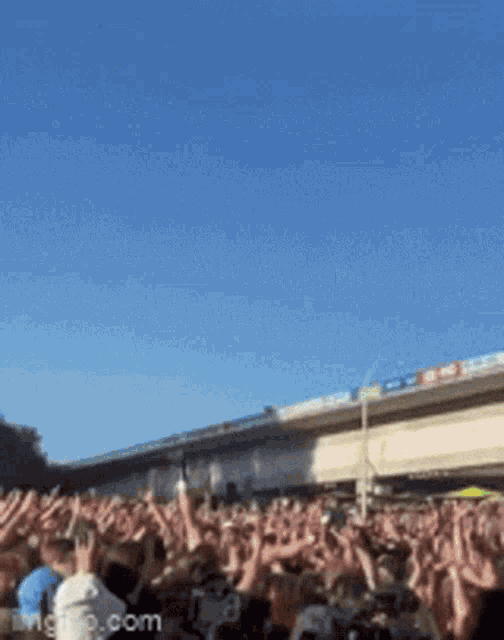 a crowd of people are raising their hands in the air at a concert