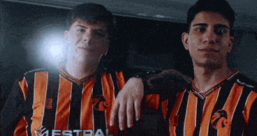 two men wearing orange and black striped jerseys with the word estral on the front