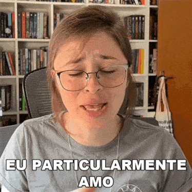 a woman wearing glasses says eu particularmente amo in front of a bookshelf