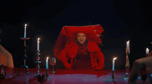 a woman in a red dress is surrounded by lit candles and says i warned you