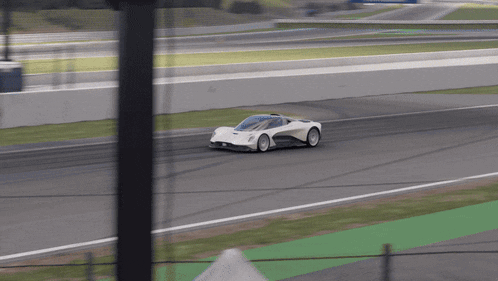 a white sports car is driving down a track