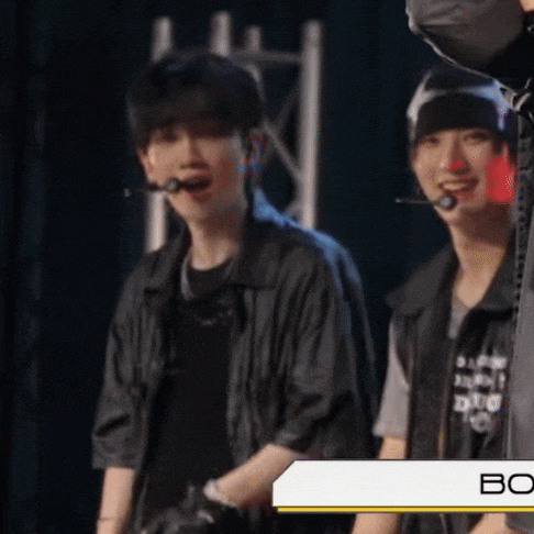 two men are standing next to each other and one has a microphone in his mouth