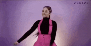 a woman in a pink dress and black turtleneck is dancing .