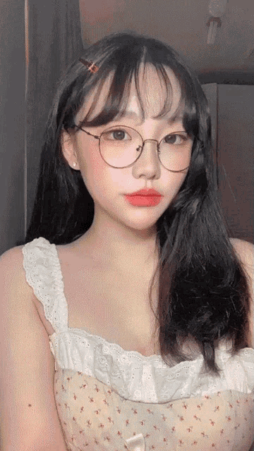 a girl wearing glasses and a white top