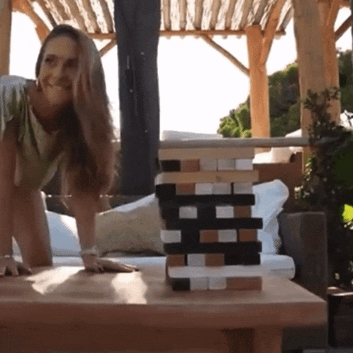 a woman stands next to a stack of wooden blocks with the letter h on them