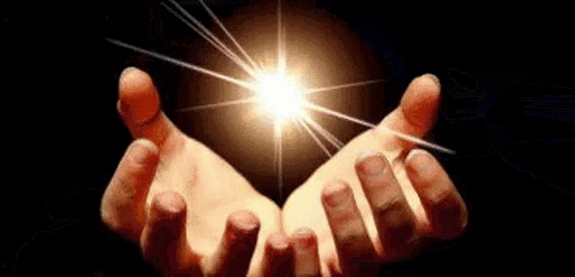 a close up of a person 's hands holding a light .