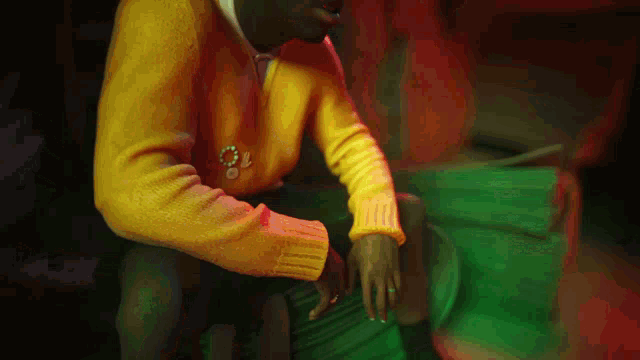 a man wearing a yellow sweater has the number 70 on his sleeve