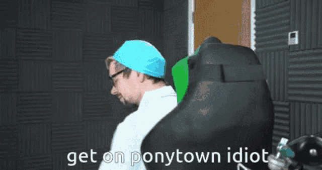 a man in a blue hat is sitting in a chair with the words get on ponytown idiot written on it