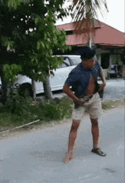 a man is standing on the side of the road holding something in his hand