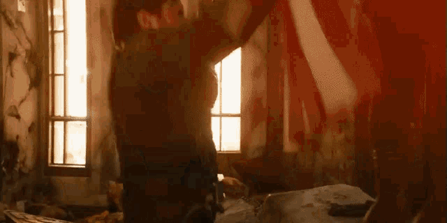 a man and woman are fighting in a room with blood coming out of the window .