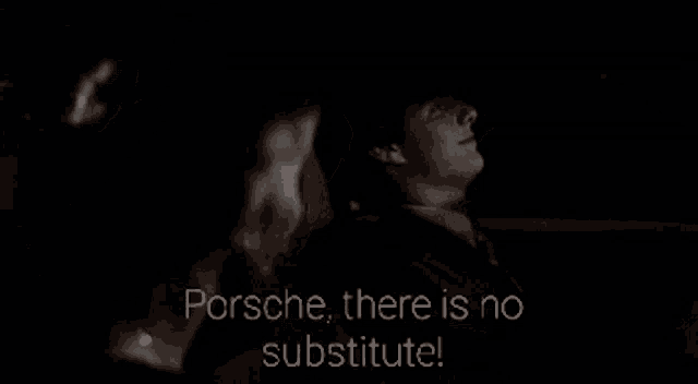 a man and a woman are sitting in a dark room and the man says porsche there is no substitute