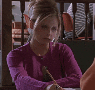 a woman in a purple sweater is sitting at a table and says " you 're not stupid "