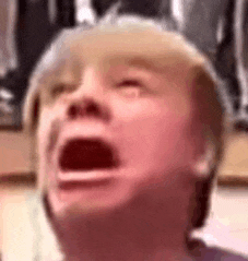 a close up of a child 's face with his mouth open .
