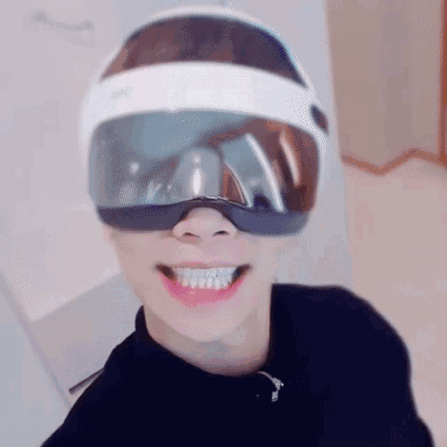 a man wearing a virtual reality headset is smiling .