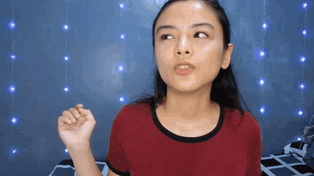 a woman in a red shirt is making a face