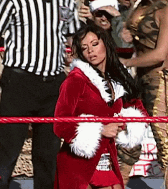 a woman in a santa suit is standing in a ring