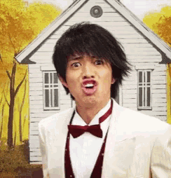 a man in a suit and bow tie is making a funny face