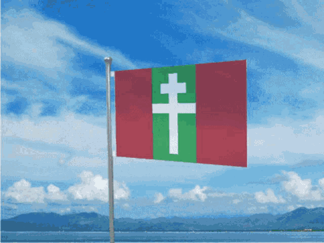 a red green and white flag with a white cross on it
