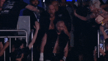 a wrestler wearing a black shirt that says aew