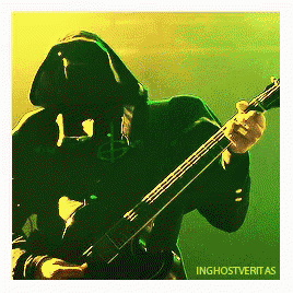 a man in a hooded jacket is playing a guitar with the words inghostveritas on the bottom