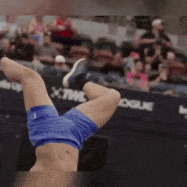 a man is doing a handstand in front of a crowd of people .