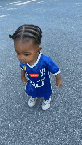 a little boy wearing a blue shirt that says ' jhene ' on it