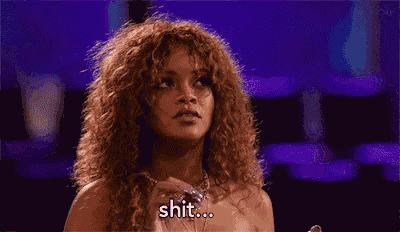 a woman with curly hair is holding a bottle of perfume and saying shit .