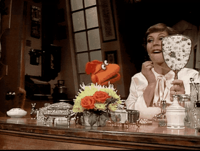 a woman is looking at herself in a mirror