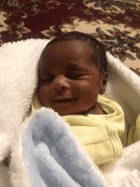 a newborn baby wrapped in a white blanket