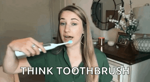 a woman is brushing her teeth with an electric toothbrush and says think toothbrush