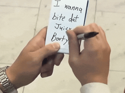 a person writing on a notepad that says i wanna bite dat juicy booty