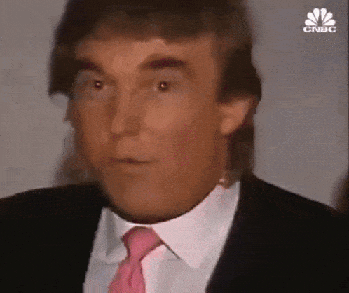 donald trump is wearing a suit and pink tie