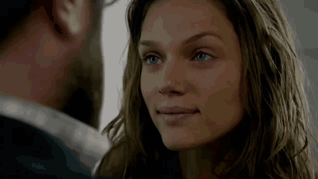 a man and a woman are looking at each other and smiling
