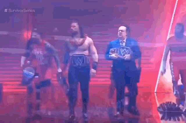 a group of wrestlers are walking down a stage and one of them has a wwe belt around his waist