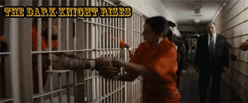 a woman in a jail cell with the dark knight rises written on the top