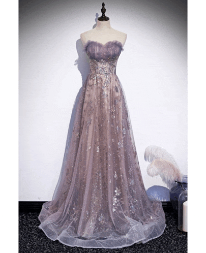 a purple dress is on a mannequin in front of a wall