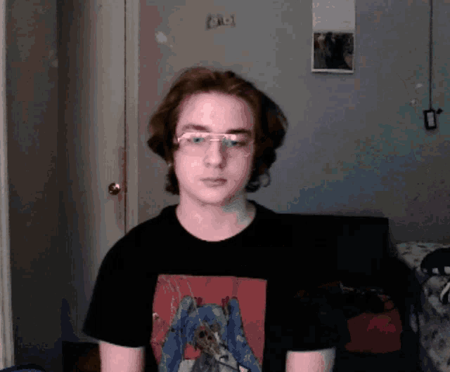 a young man wearing glasses and a t-shirt with a picture of a girl on it