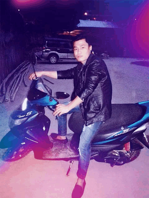 a man is sitting on a blue scooter that says yamaha on it