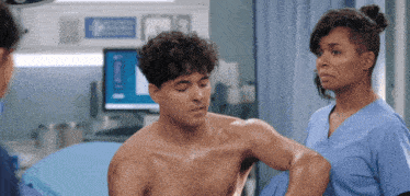 a shirtless man is being examined by a nurse in a hospital room