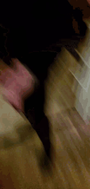 a blurry picture of a person wearing a black shirt and pink gloves .