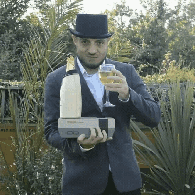 a man in a top hat holds a nintendo entertainment system and a glass of wine