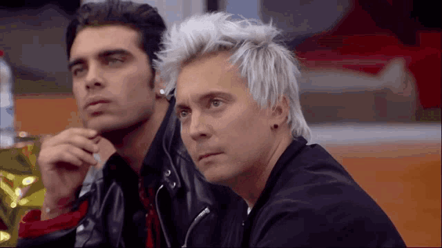 two men are sitting next to each other and one of them has white hair