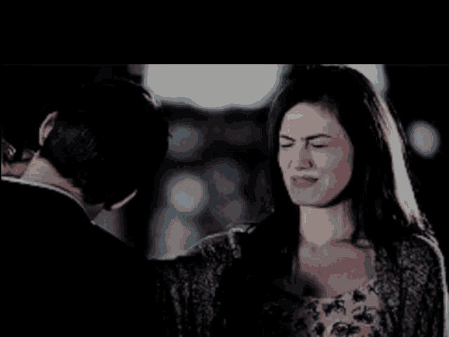 a man and a woman are looking at each other and the woman has a serious look on her face