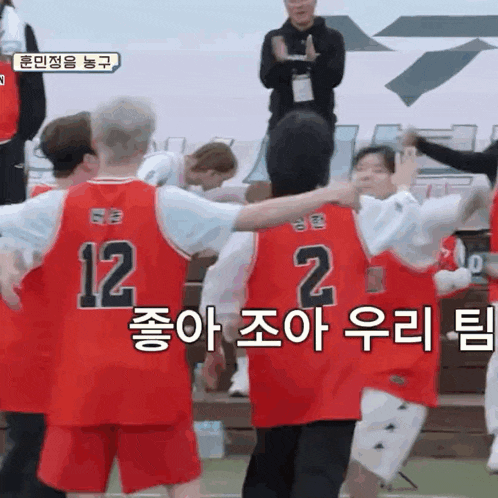 a group of basketball players wearing red uniforms with the number 12 on them