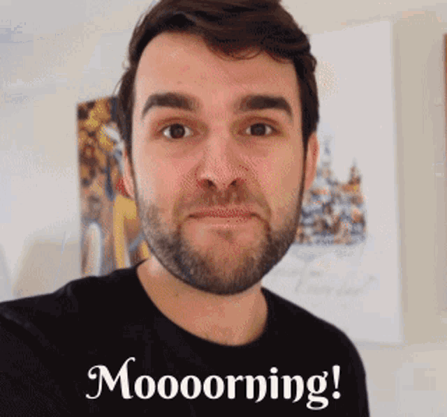 a man with a beard is wearing a black shirt that says moooorning on it