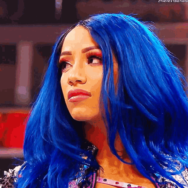 a woman with blue hair is looking at the camera