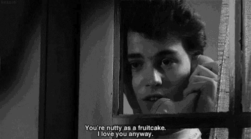 a black and white photo of a man talking on a phone with the caption " you 're nutty as a fruitcake "