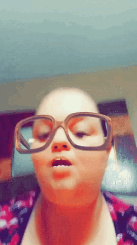 a close up of a woman wearing glasses making a face