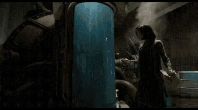 a woman is standing next to a man in a tank in a room .