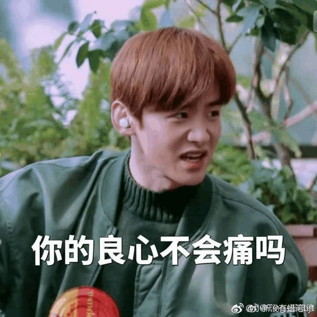 a young man with red hair is wearing a green jacket and a green sweater